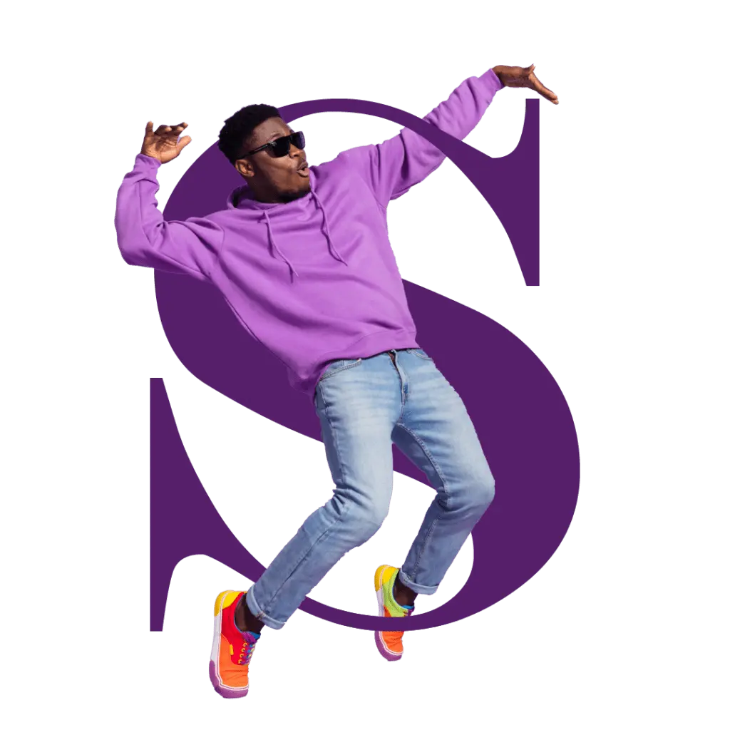 A young man wearing a purple hoodie, blue jeans, and colorful sneakers jumps energetically in front of a large stylized purple letter "S", expressing creativity and movement.